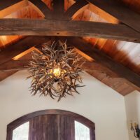 Elegant Holland Peak mule deer antler ball chandelier in a timber frame entryway