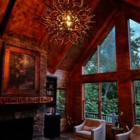 Handcrafted Tumbleweed mule deer antler ball chandelier in a rustic wood-beamed living room