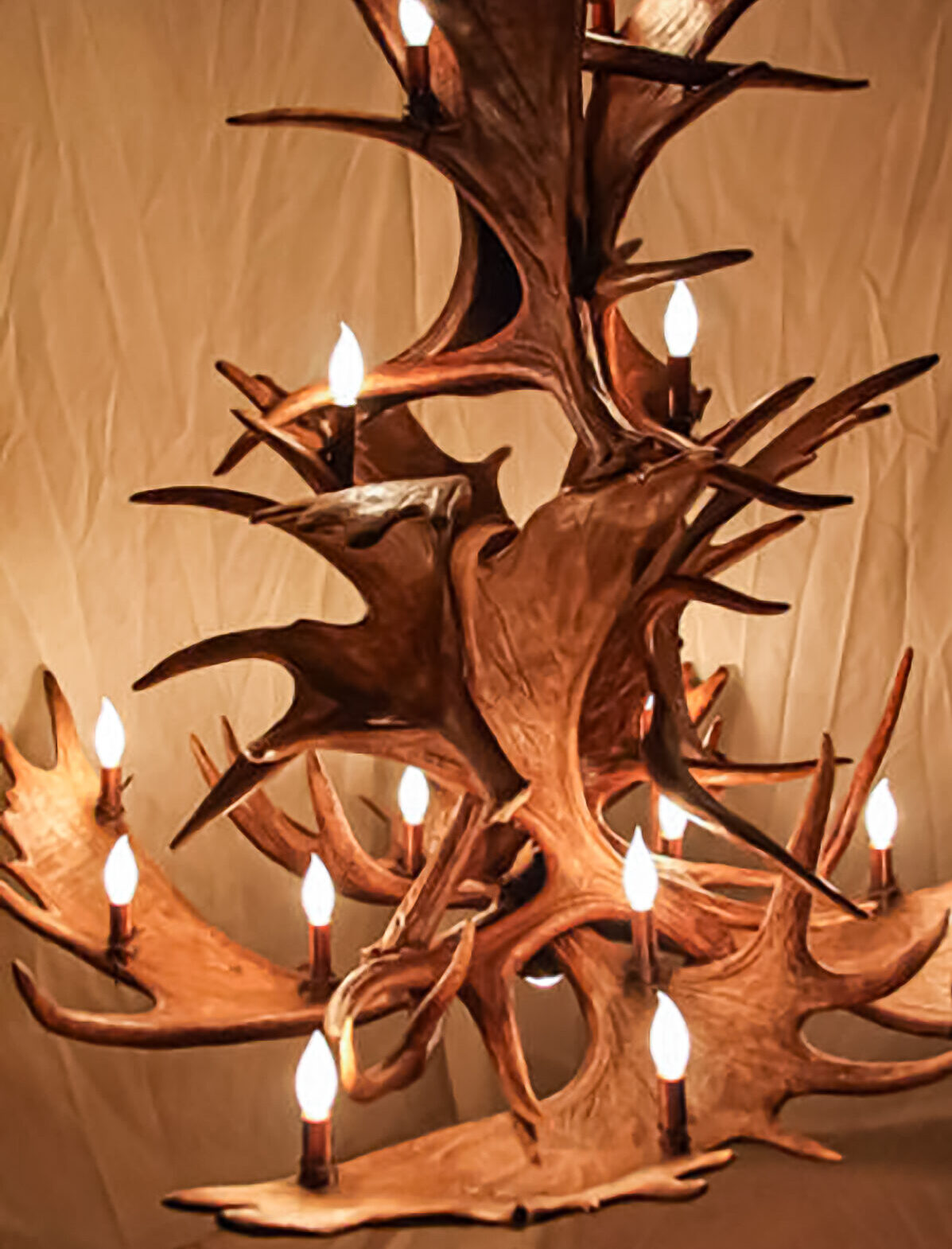 Towering moose antler chandelier with sprawling antlers and warm ambient lighting