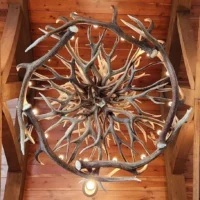 A direct view from below of the handcrafted Holland Peak antler chandelier, showcasing the intricate, symmetrical woven antler design and warm lighting.