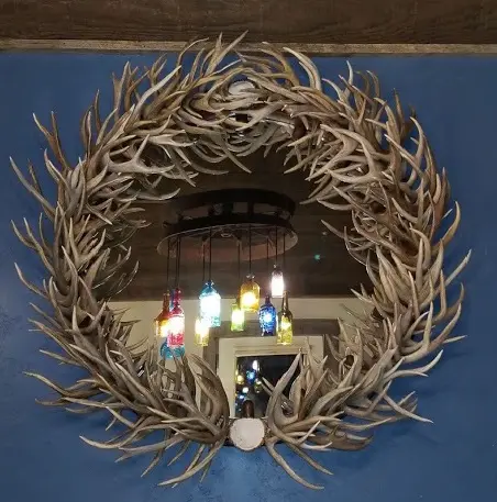 Handcrafted round deer antler mirror with a rustic finish.