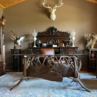 Luxury handcrafted trophy antler desk with glass top in rustic office by Montana Antler Works