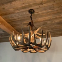 Custom trophy single-tier whitetail antler chandelier by Montana Antler Works installed on a rustic wood plank ceiling