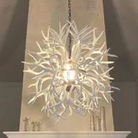 Modern white deer antler chandelier installed in a rustic chic living room